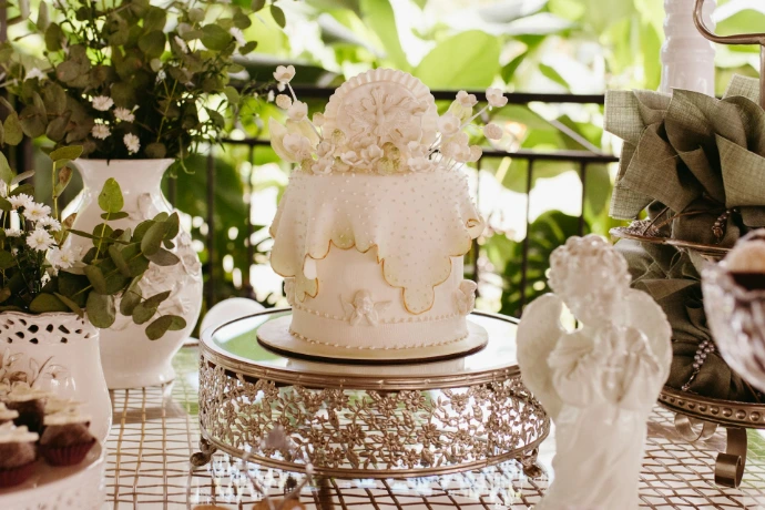 Elegant white cake on a silver stand with angel decoration